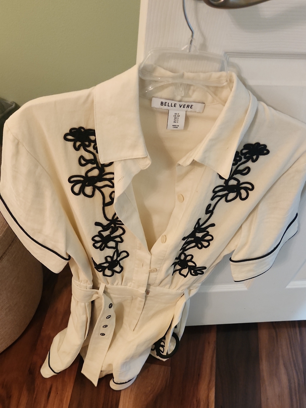 Belle Vere Cream Short-Sleeve Button-Front Romper with Black Floral Trim.